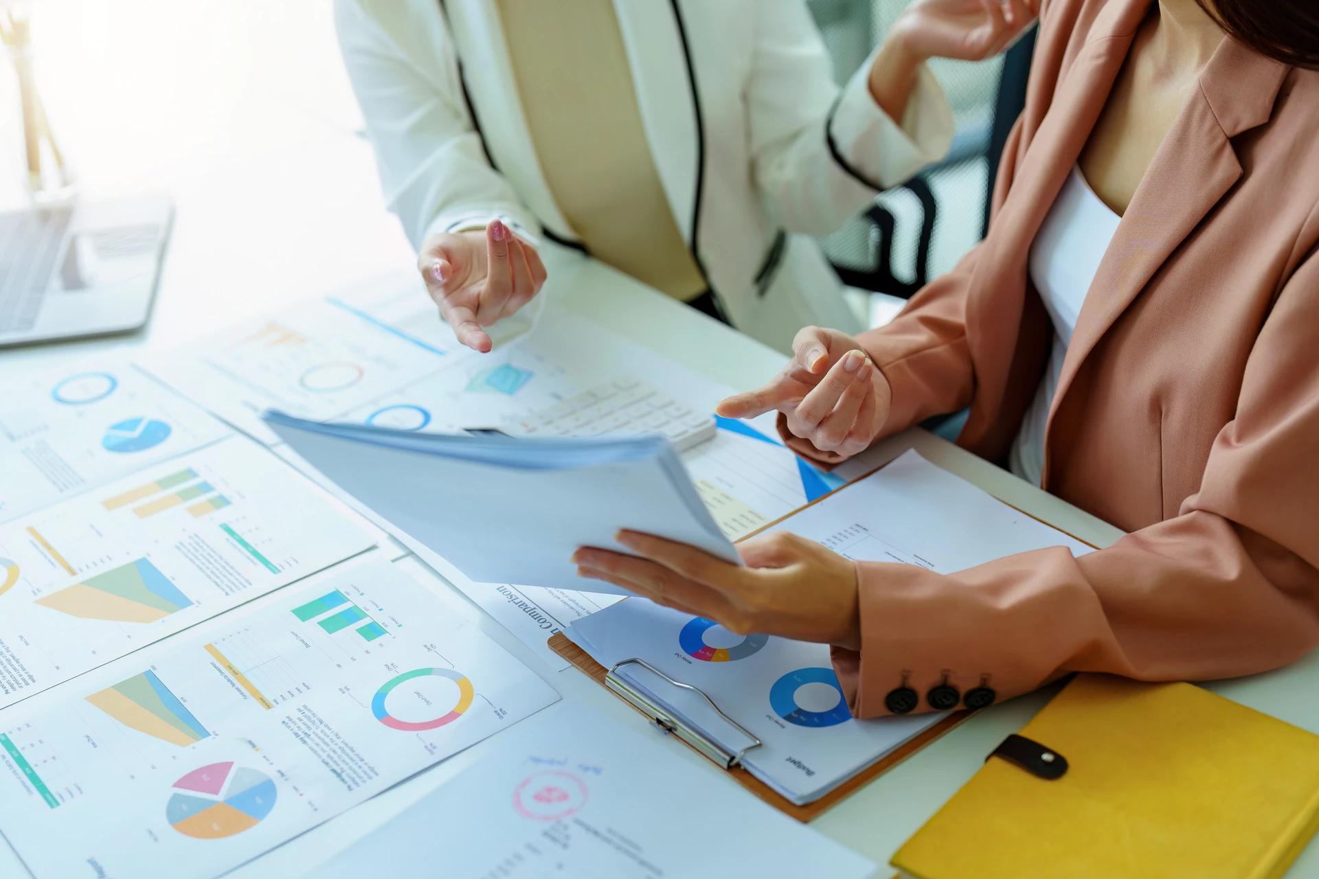 Two business professionals reviewing charts and documents.